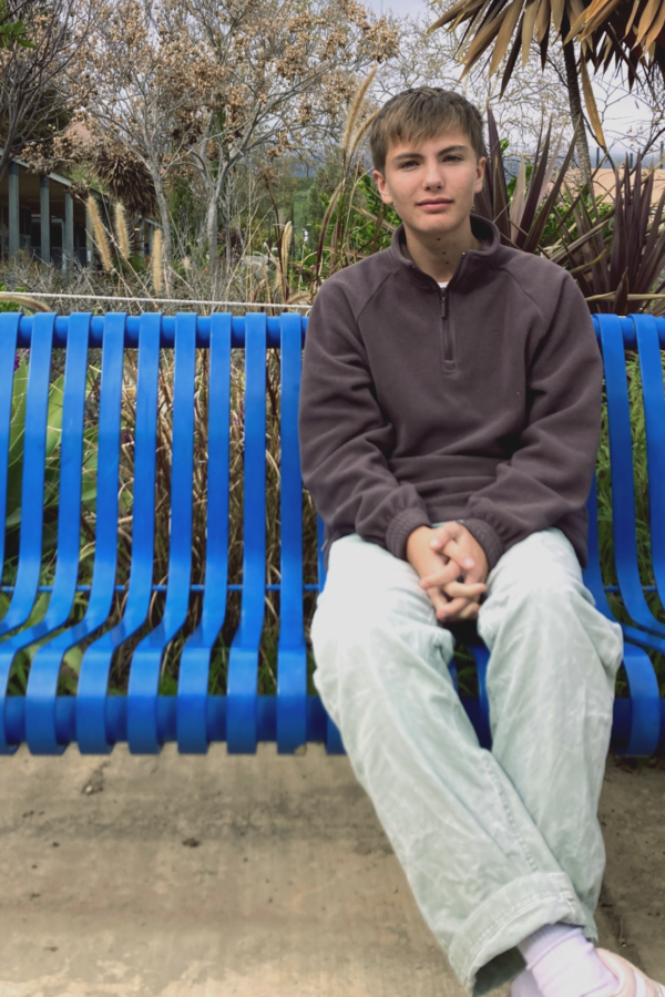 Freshman Owen Andrews sits on a bench outside the library.