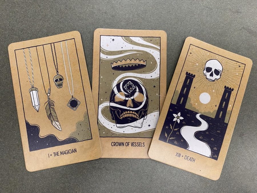 Three tarot cards, the magician, crown of vessels, and death.