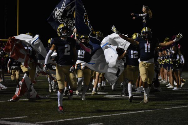 Football team running through banner