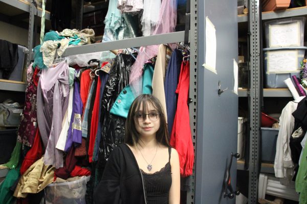 Inda stands in front of one of the costume room’s towering walls of costumes