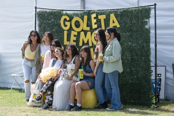 Group of people poses in front of a Goleta Lemon Festival sign