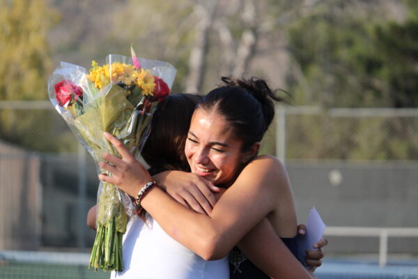 Ellie Triplett (12) hugs her teammate during the girls tennis Senior Night.