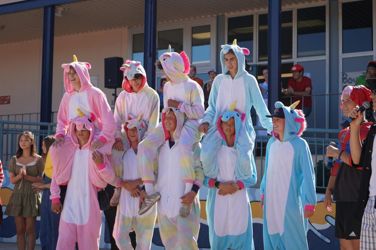 Students dressed as unicorns sit on each other’s shoulder's for the group category in the Halloween costume competition.