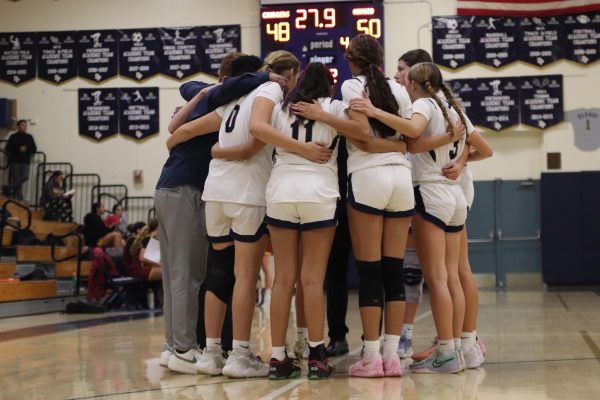 The girls coming together at the end of a game.