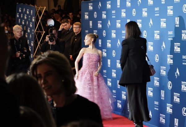 Ariana Grande arriving at the red carpet in a soft pink ball gown with flower attachments. 