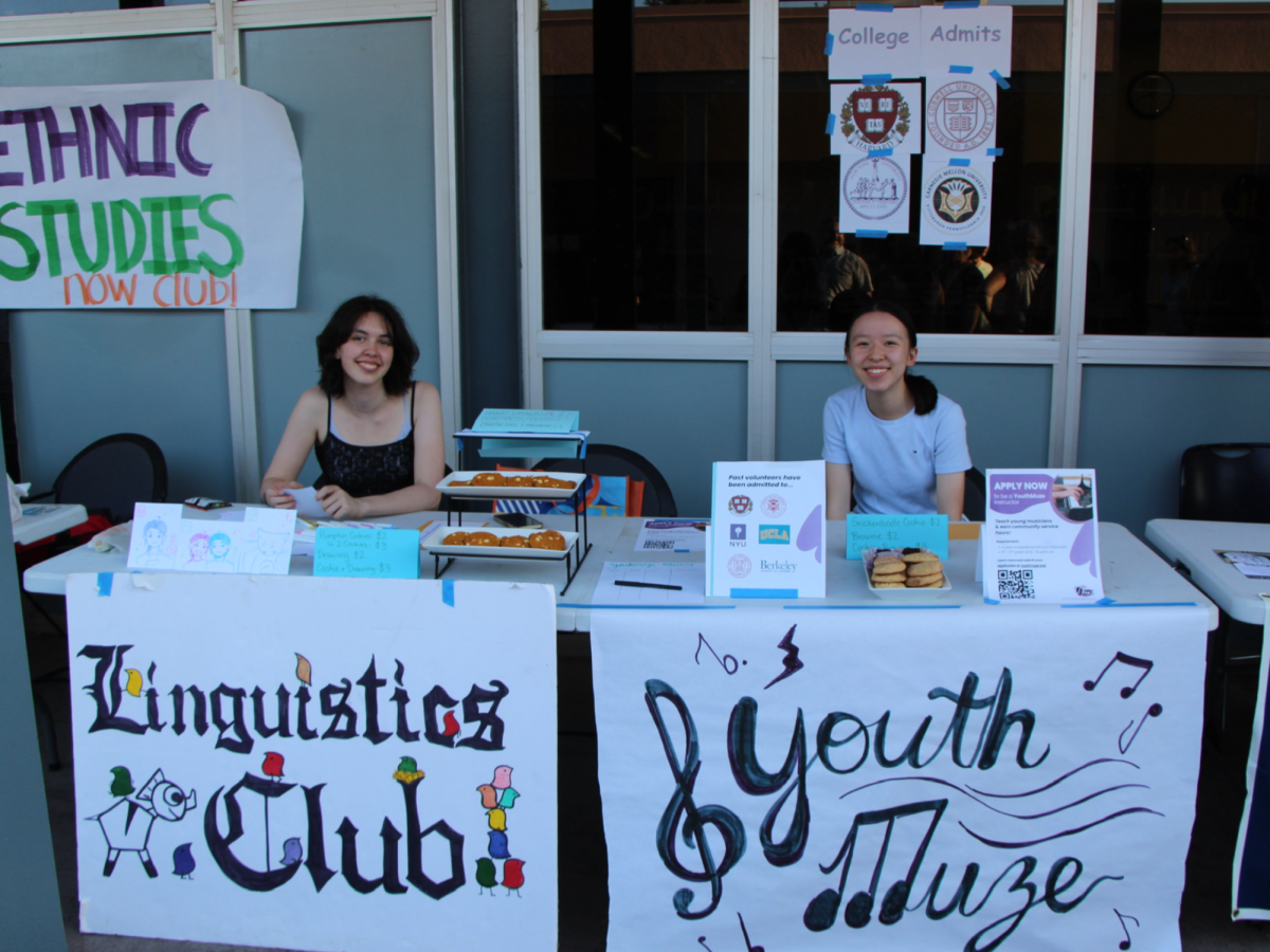 (Left to Right) Sasha Dozier (12) represents Linguistic club at back to school night and at the table next to her sits Elaine Hu (11) for Youth Muze