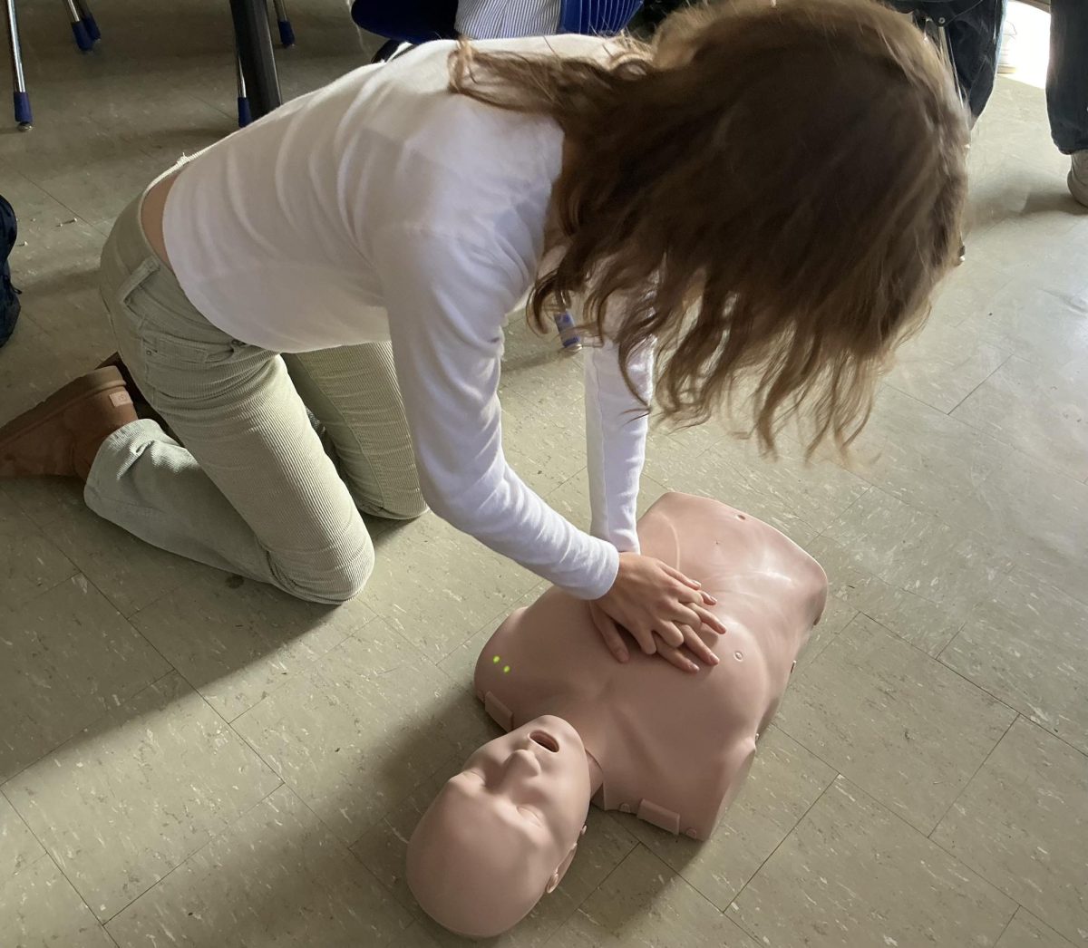 Student preforming CPR on practice dummy
