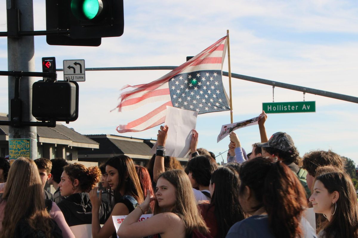 DPHS students marching towards Girsh pack for the Free America Walkout Protest, waving a torn upside-down United States flag